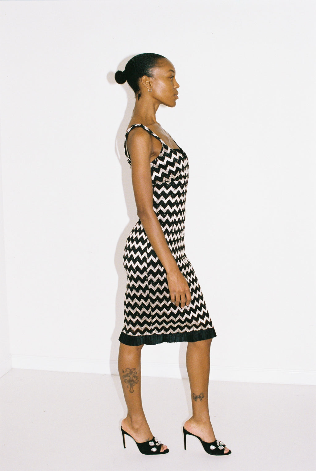 Woman wearing a black and silver zigzag dress against a white background