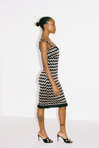 Woman wearing a black and silver zigzag dress against a white background