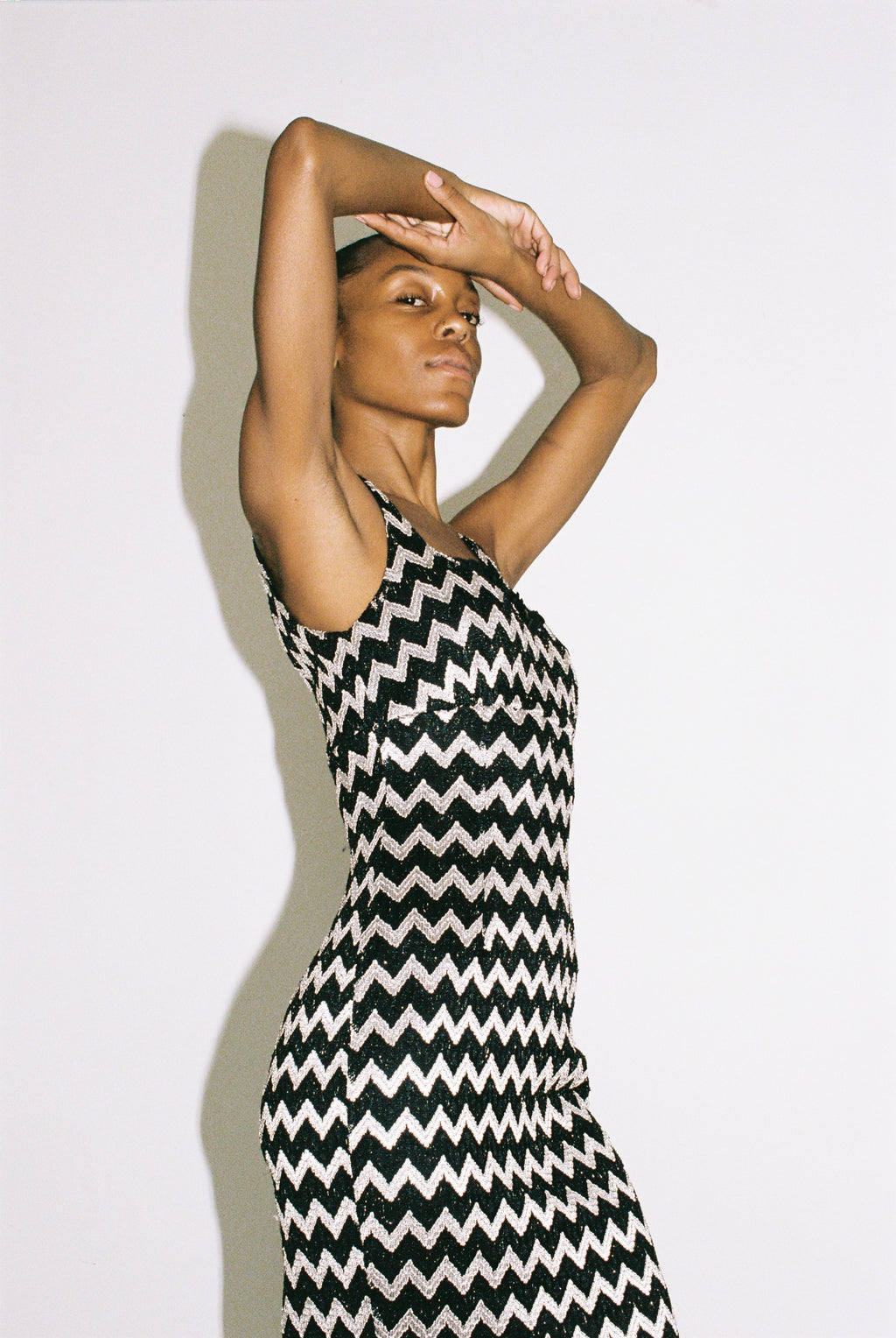 Woman wearing a black and silver zigzag dress against a plain background