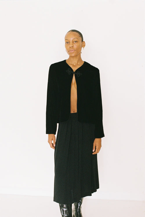Person wearing a black jacket and skirt on a white background