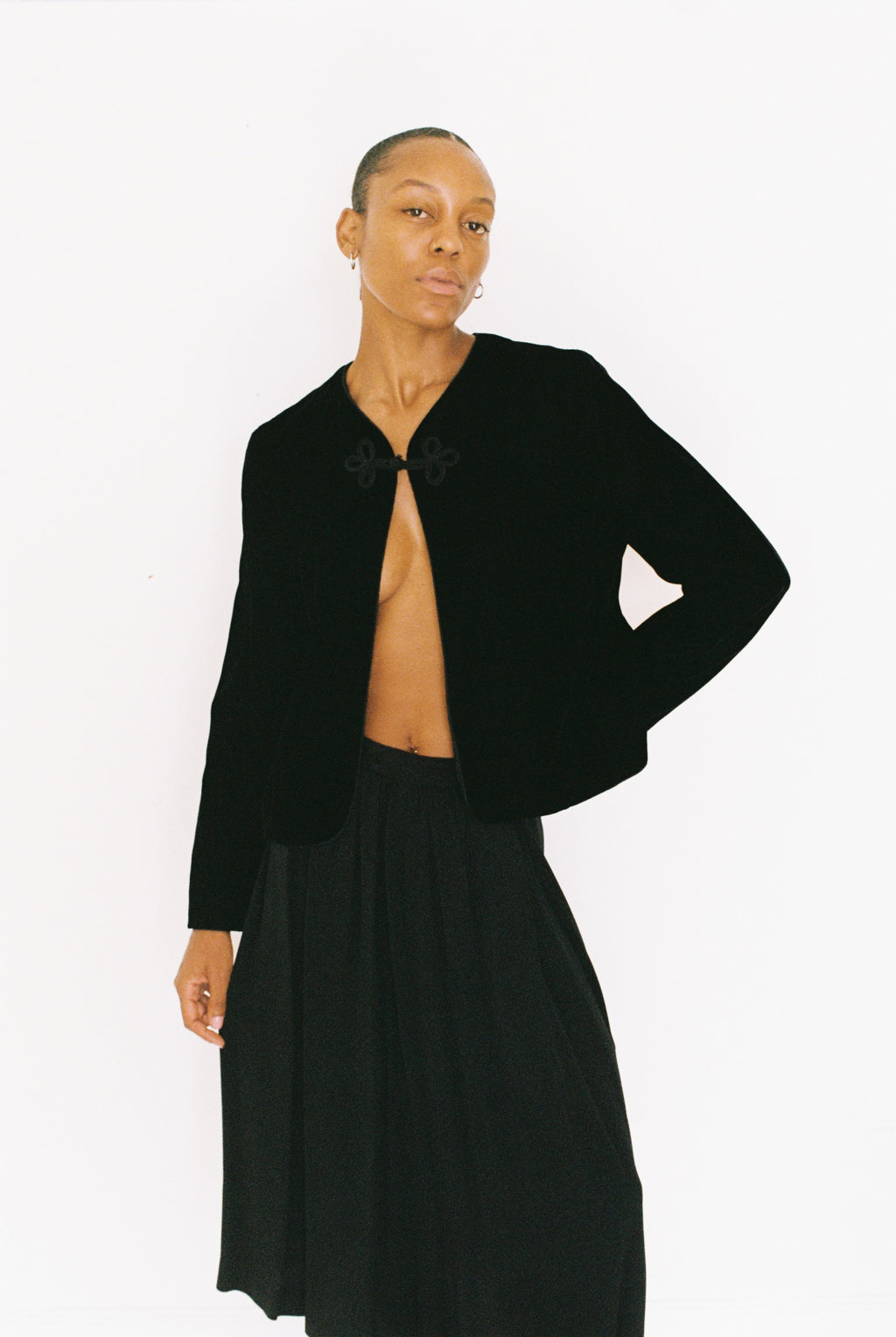 Person wearing a black jacket and skirt on a white background
