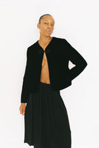 Person wearing a black jacket and skirt on a white background