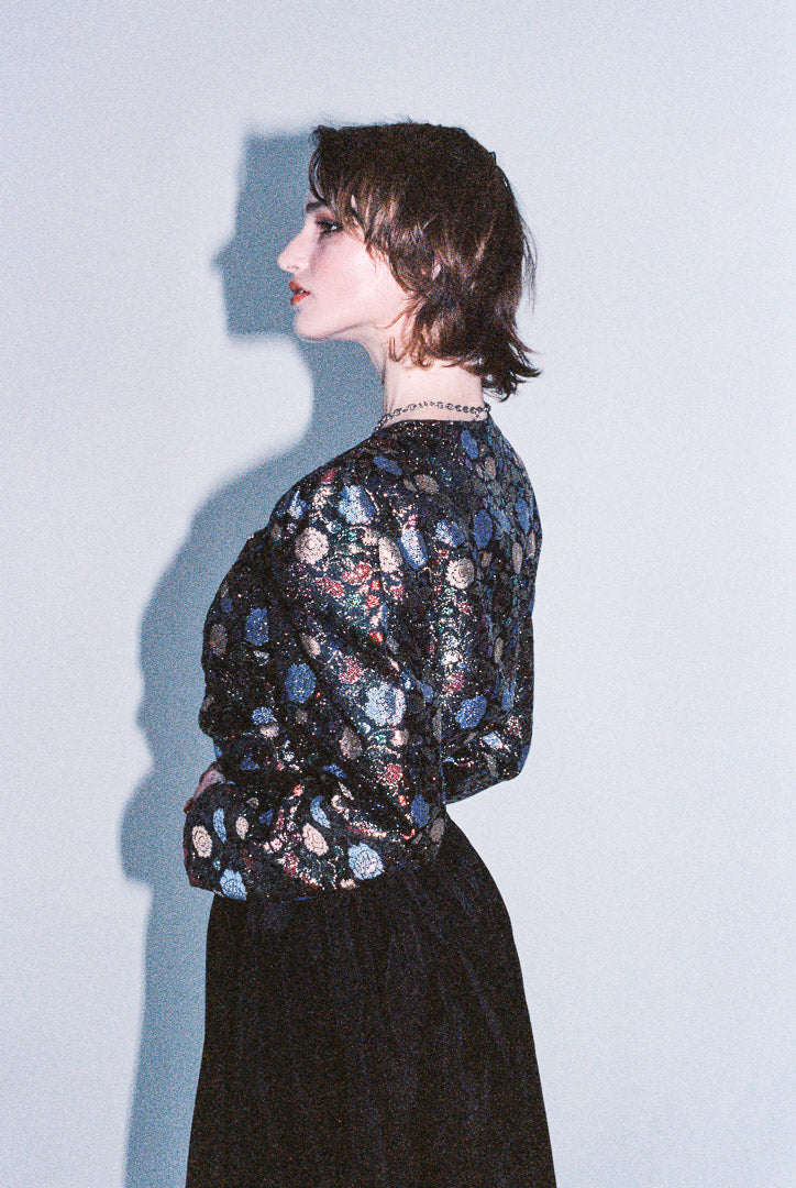 Person wearing a floral blouse against a light blue background