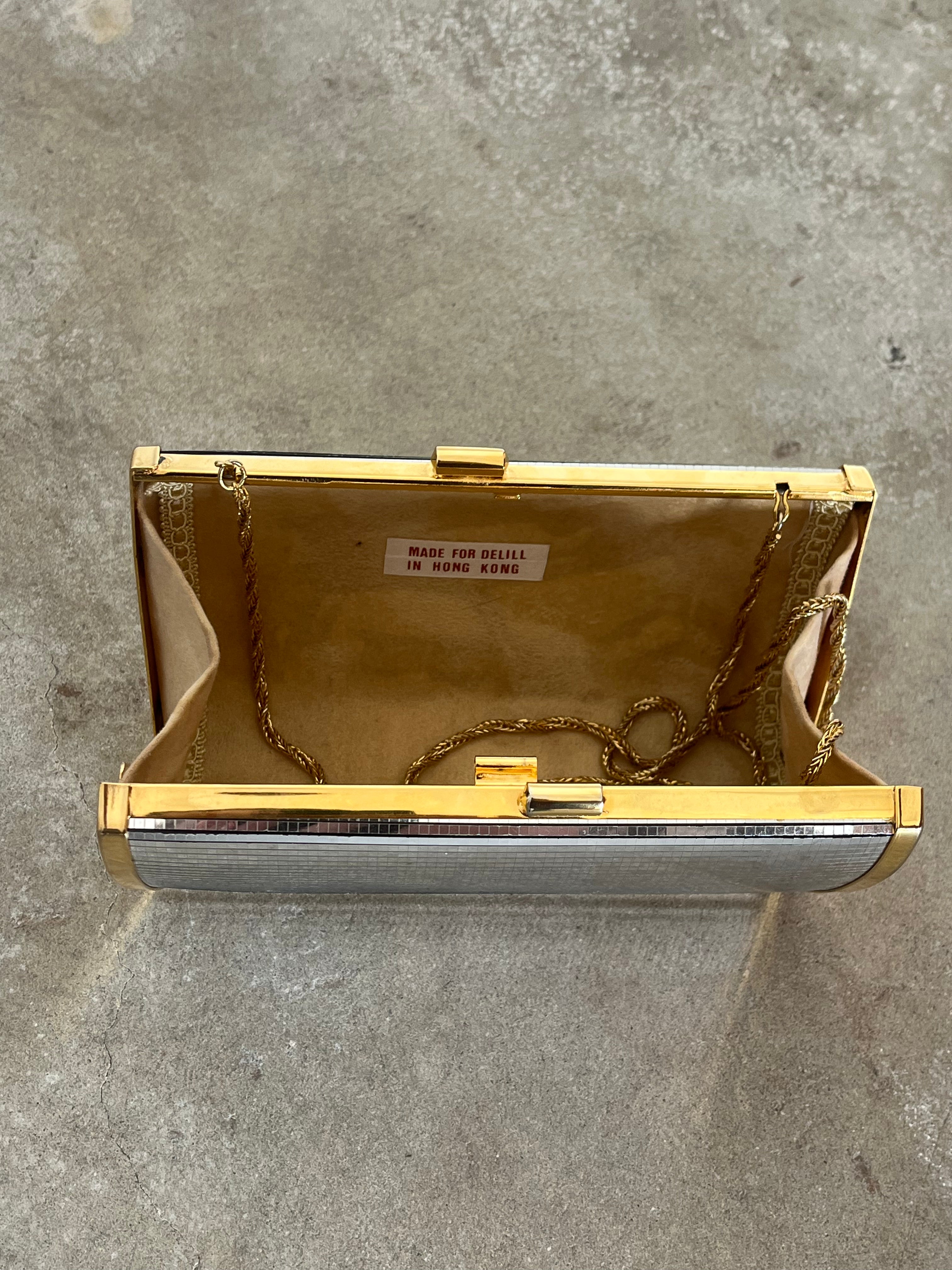 Gold and silver clutch on a gray concrete surface