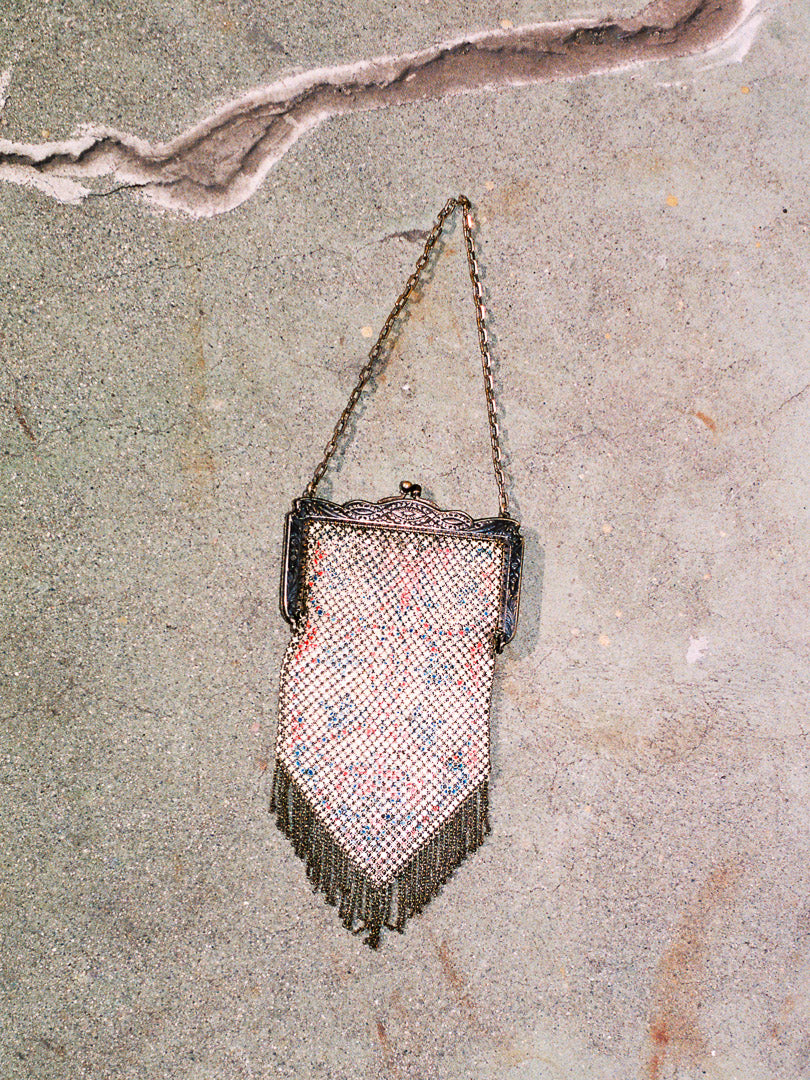 Vintage mesh handbag with chain strap on a textured surface
