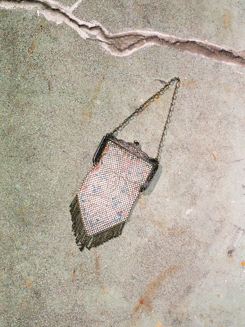 Vintage mesh handbag with chain strap on a textured surface