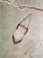 Vintage mesh handbag with chain strap on a textured surface