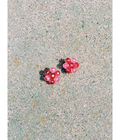 Pink earrings on a textured beige surface