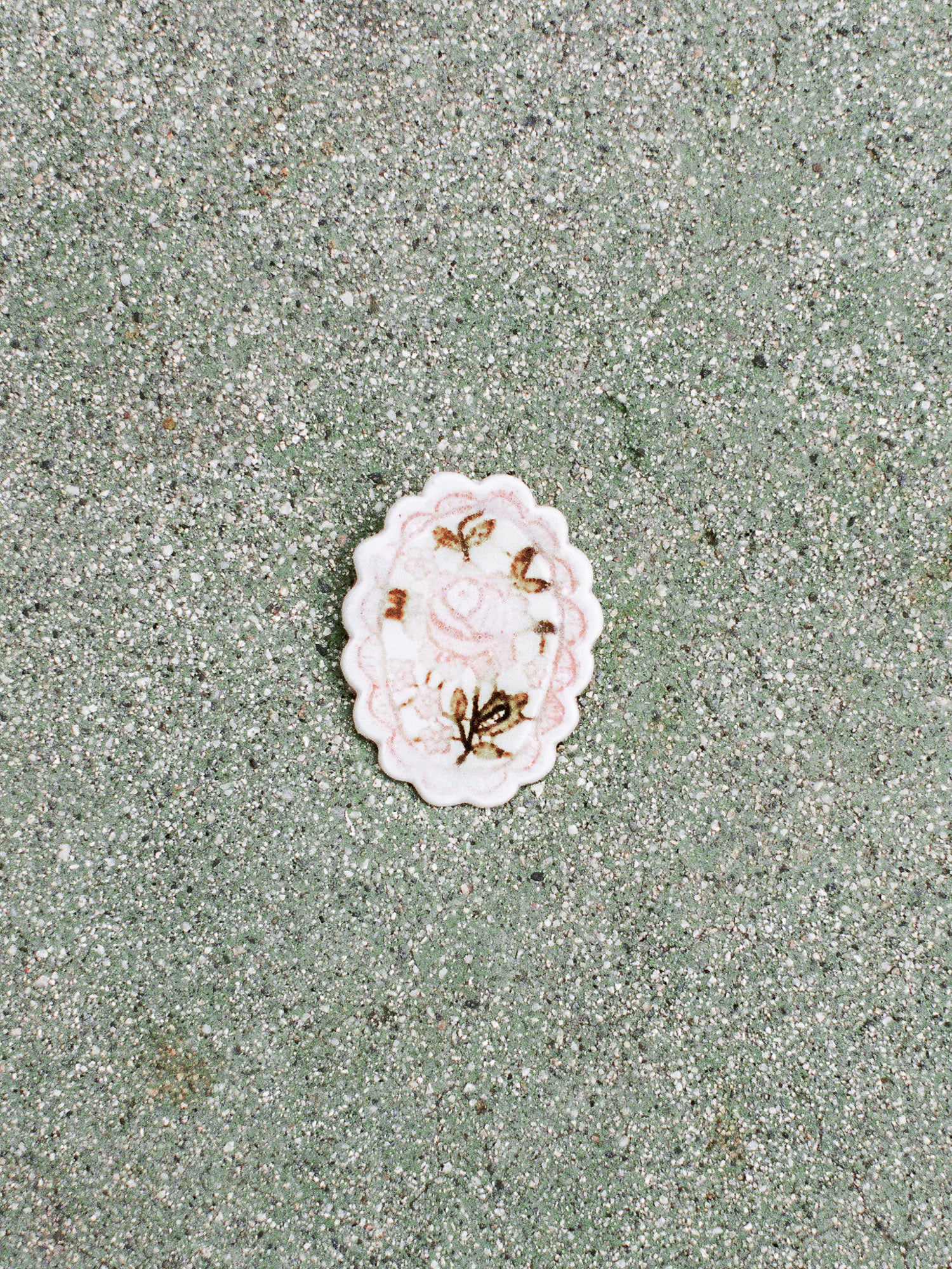 White shell with floral design on a textured green surface