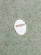 Ring on a white shell with sand background