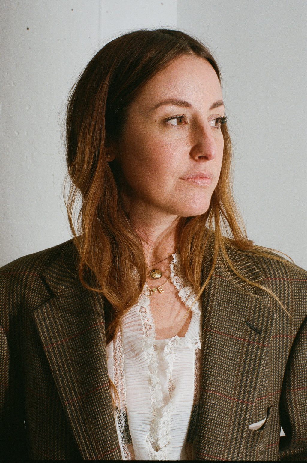Woman wearing a patterned blazer against a white wall