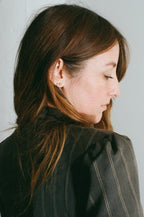 Woman wearing a dark pinstripe jacket against a light background
