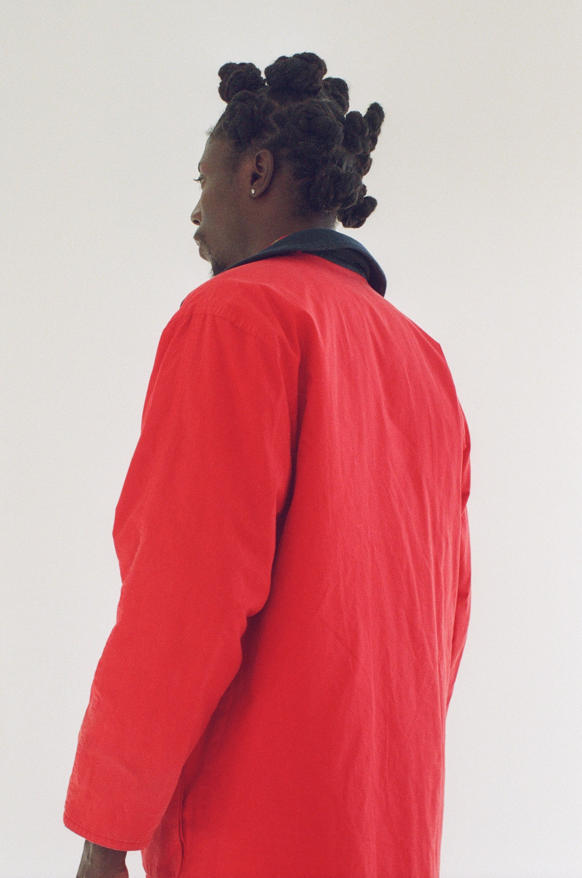Person wearing a bright red coat against a plain background