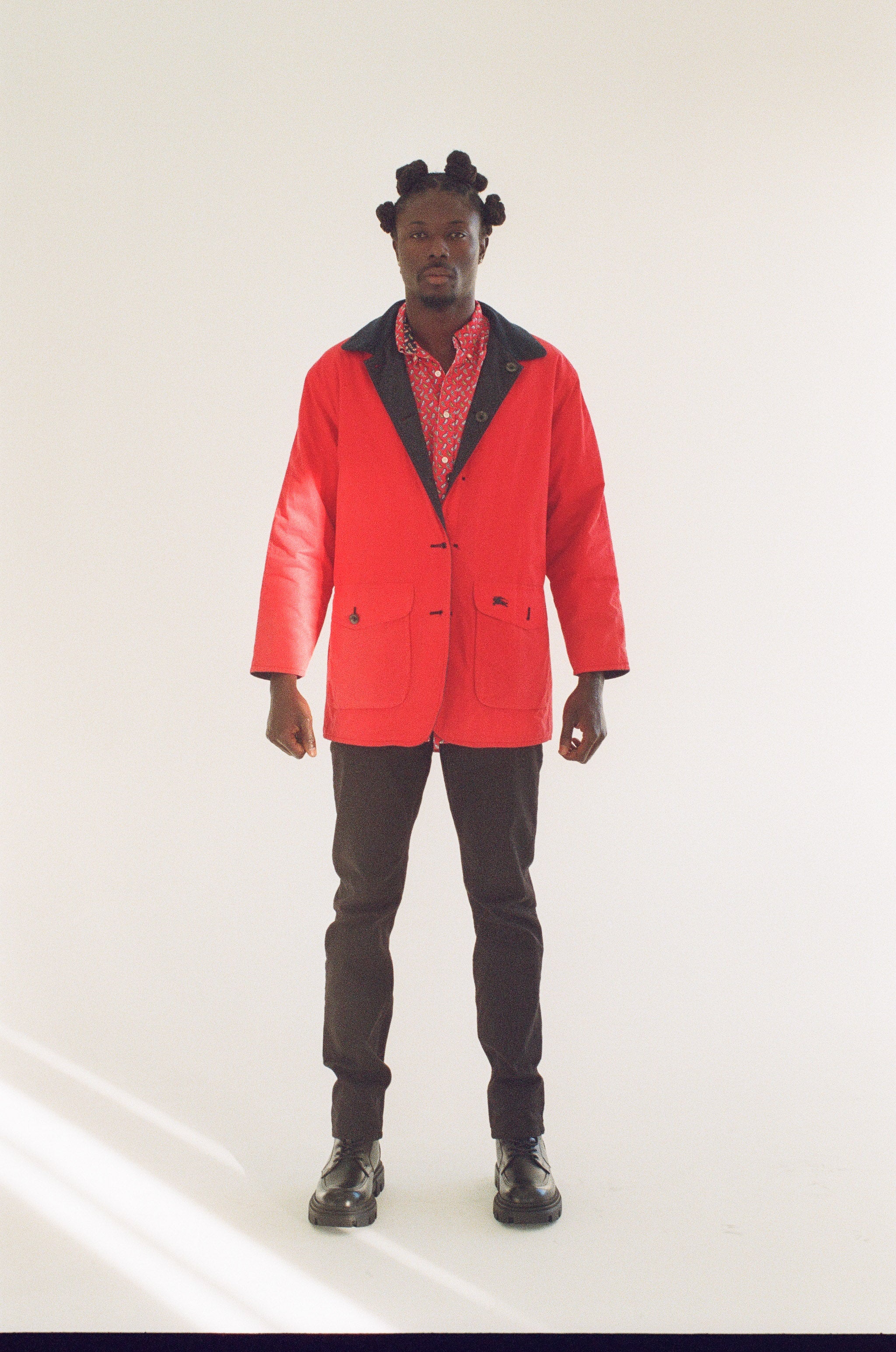 Person wearing a red coat with black lapels on a white background