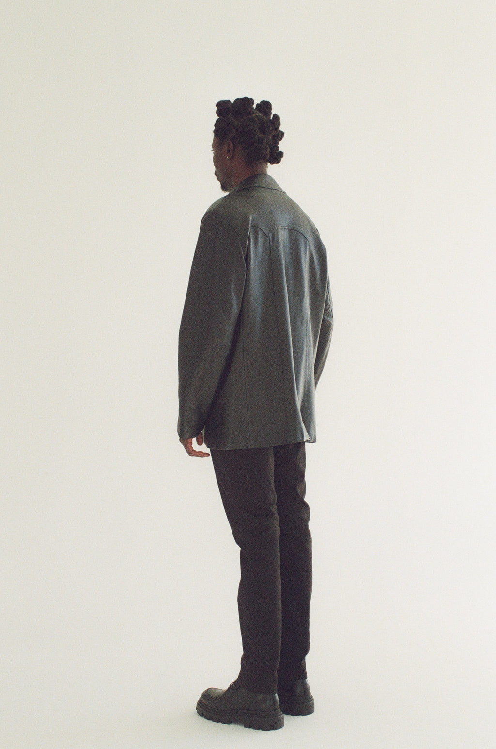 Person wearing a black blazer and black pants on a white background