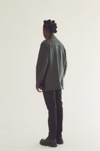 Person wearing a black blazer and black pants on a white background