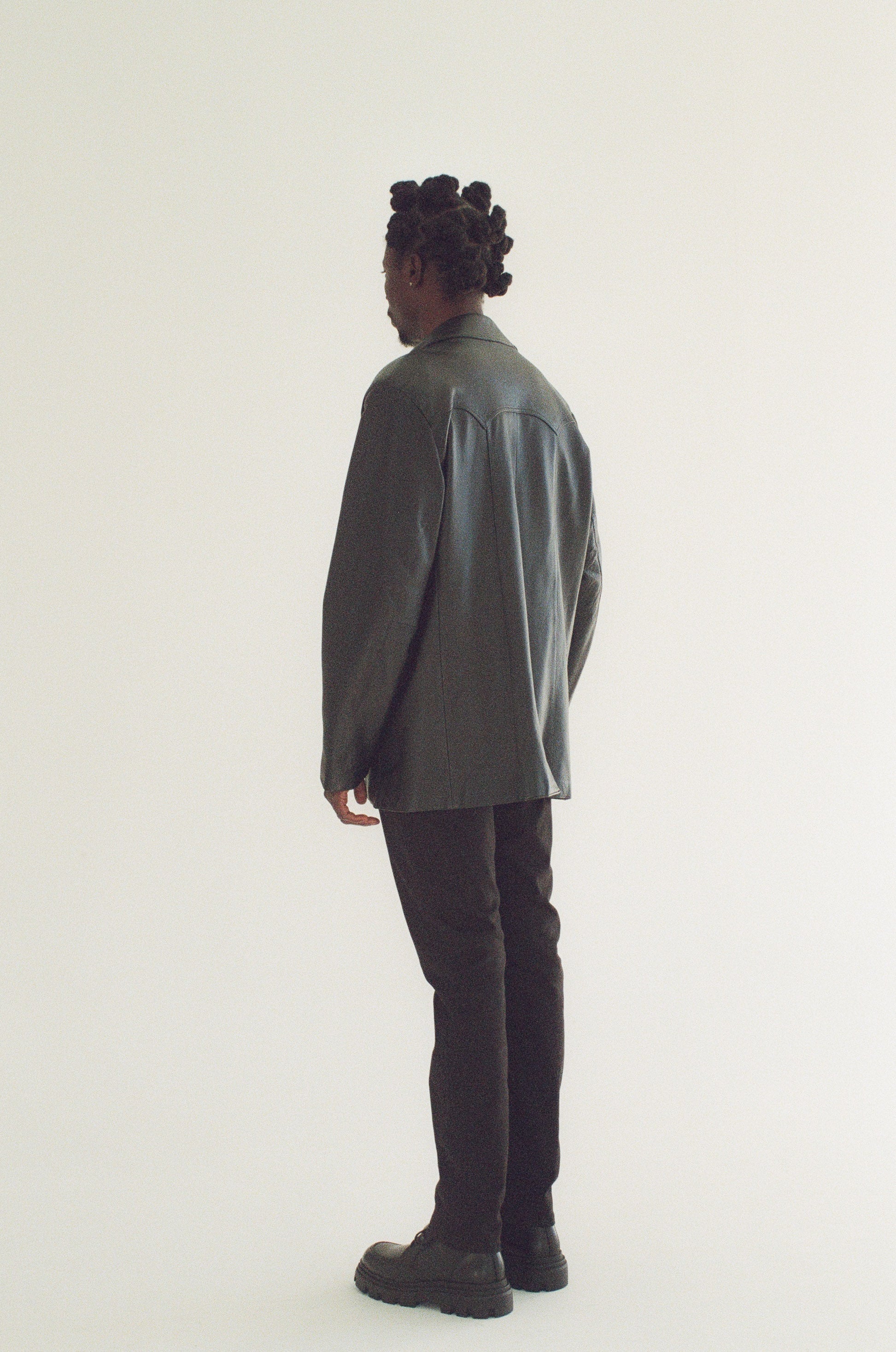 Person wearing a black blazer and black pants on a white background