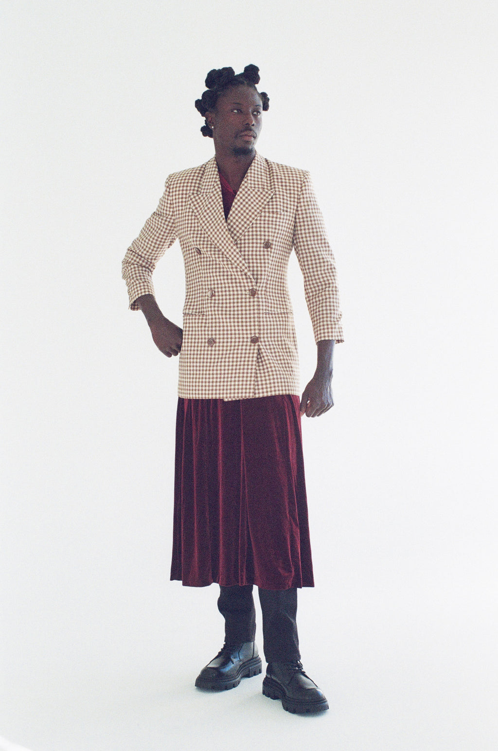 Person wearing a patterned blazer and skirt on a white background