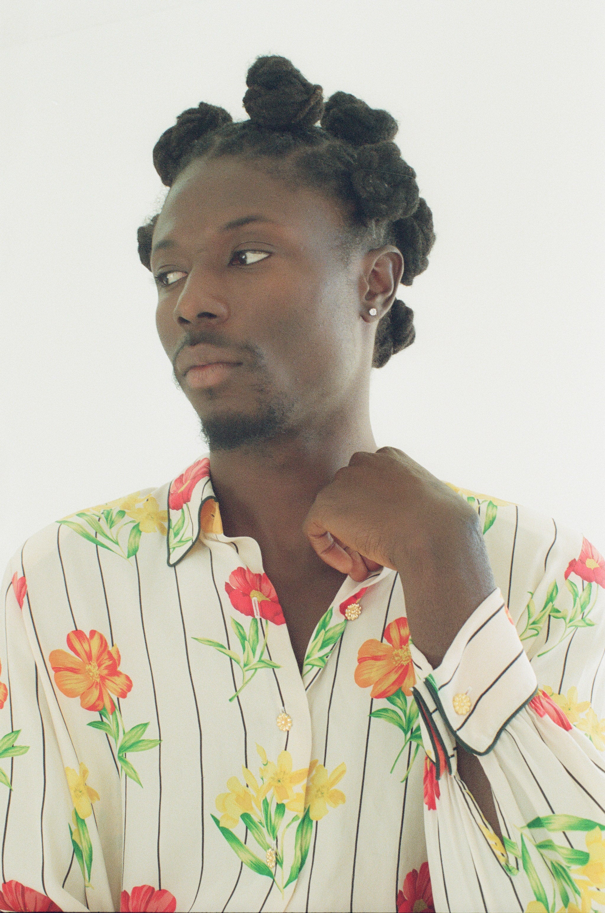Person wearing a floral patterned shirt against a plain background