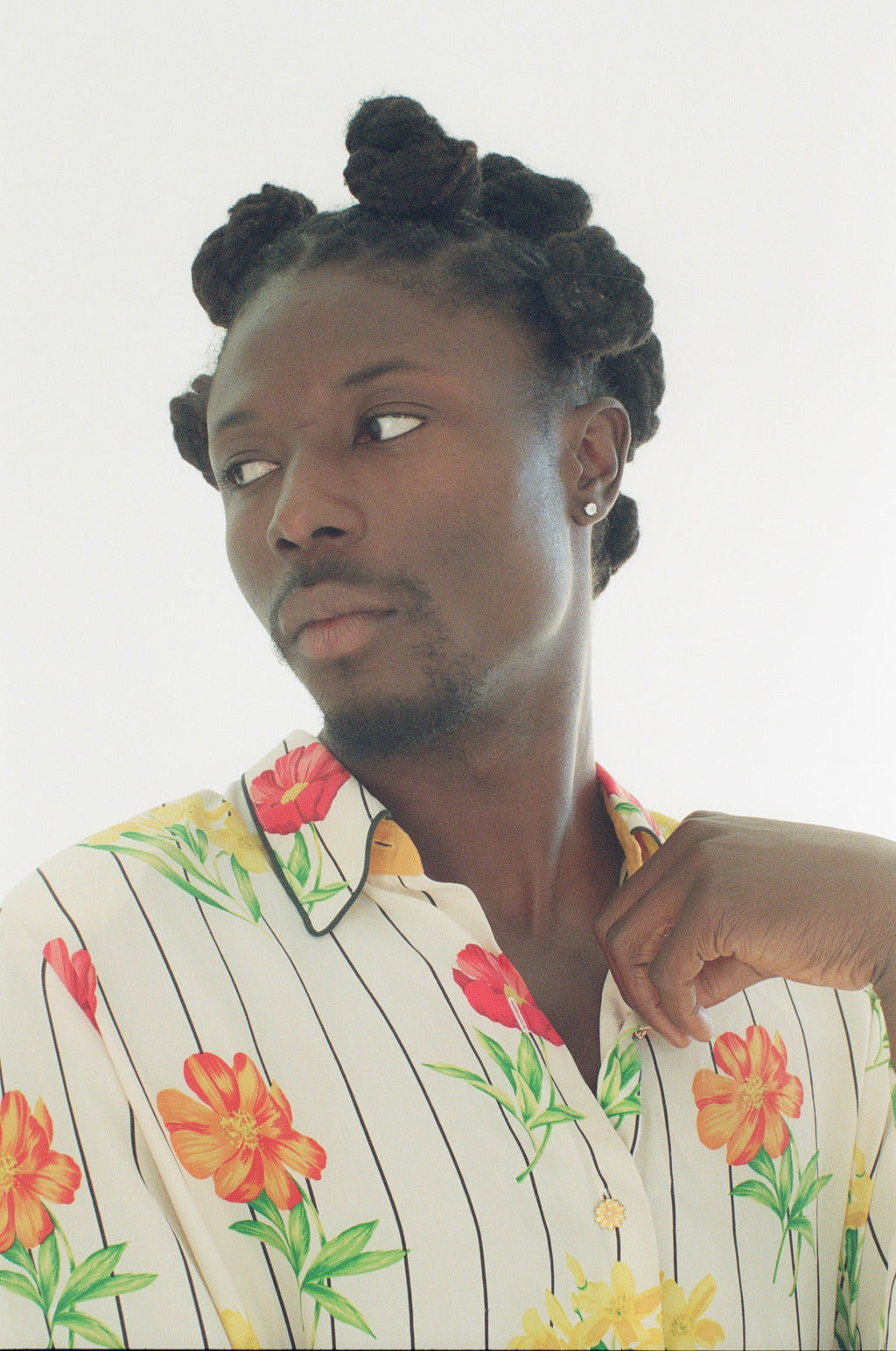 Person wearing a colorful floral shirt with a white background