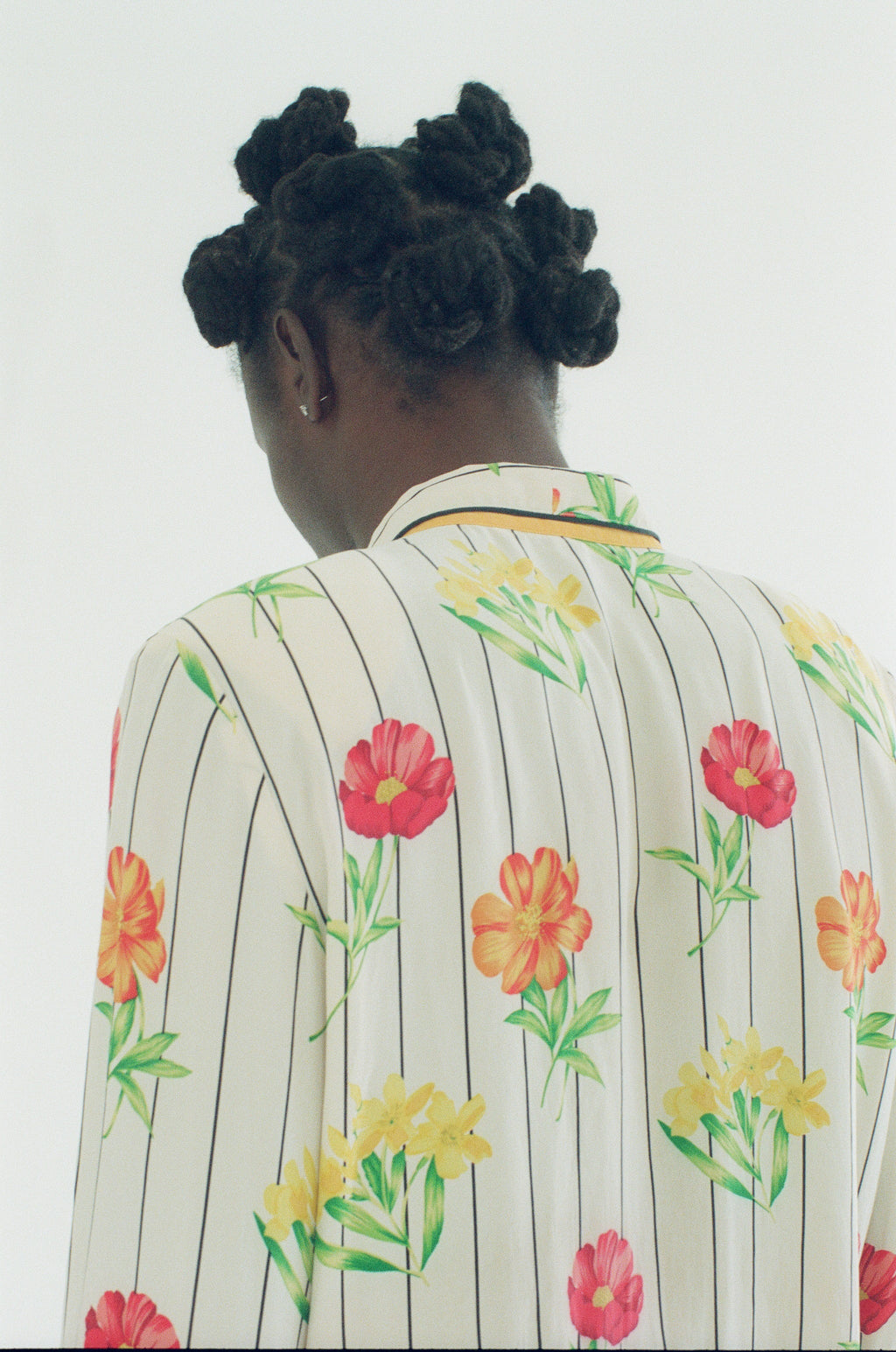 Person wearing a floral-patterned outfit with a plain background