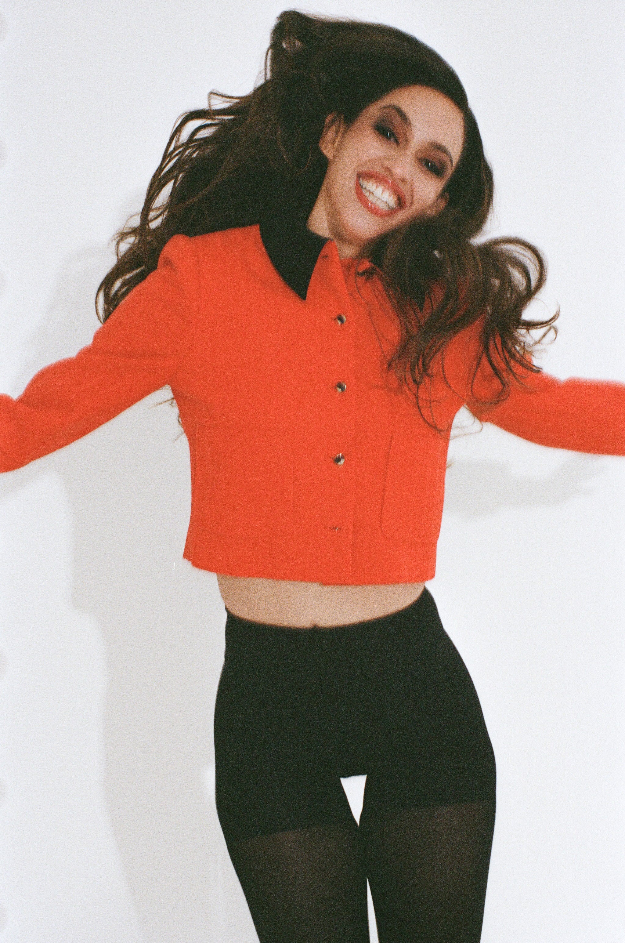 Person wearing a bright red jacket with black accents on a white background