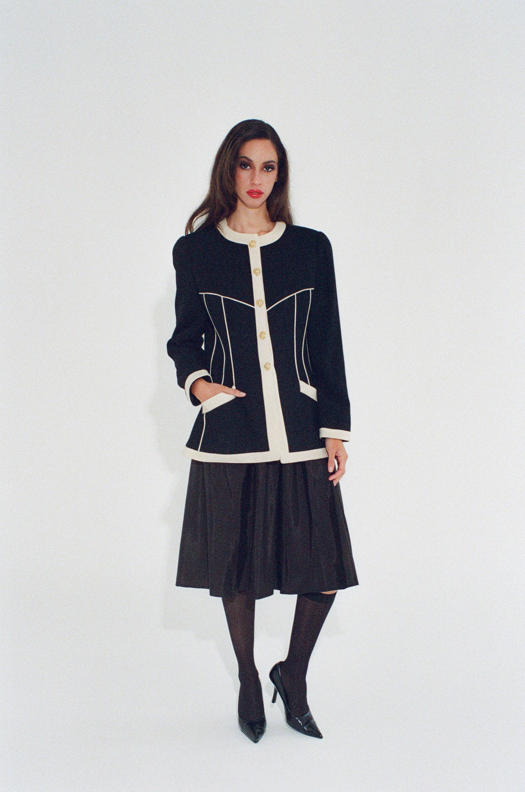 Woman wearing a black and white jacket with a white background