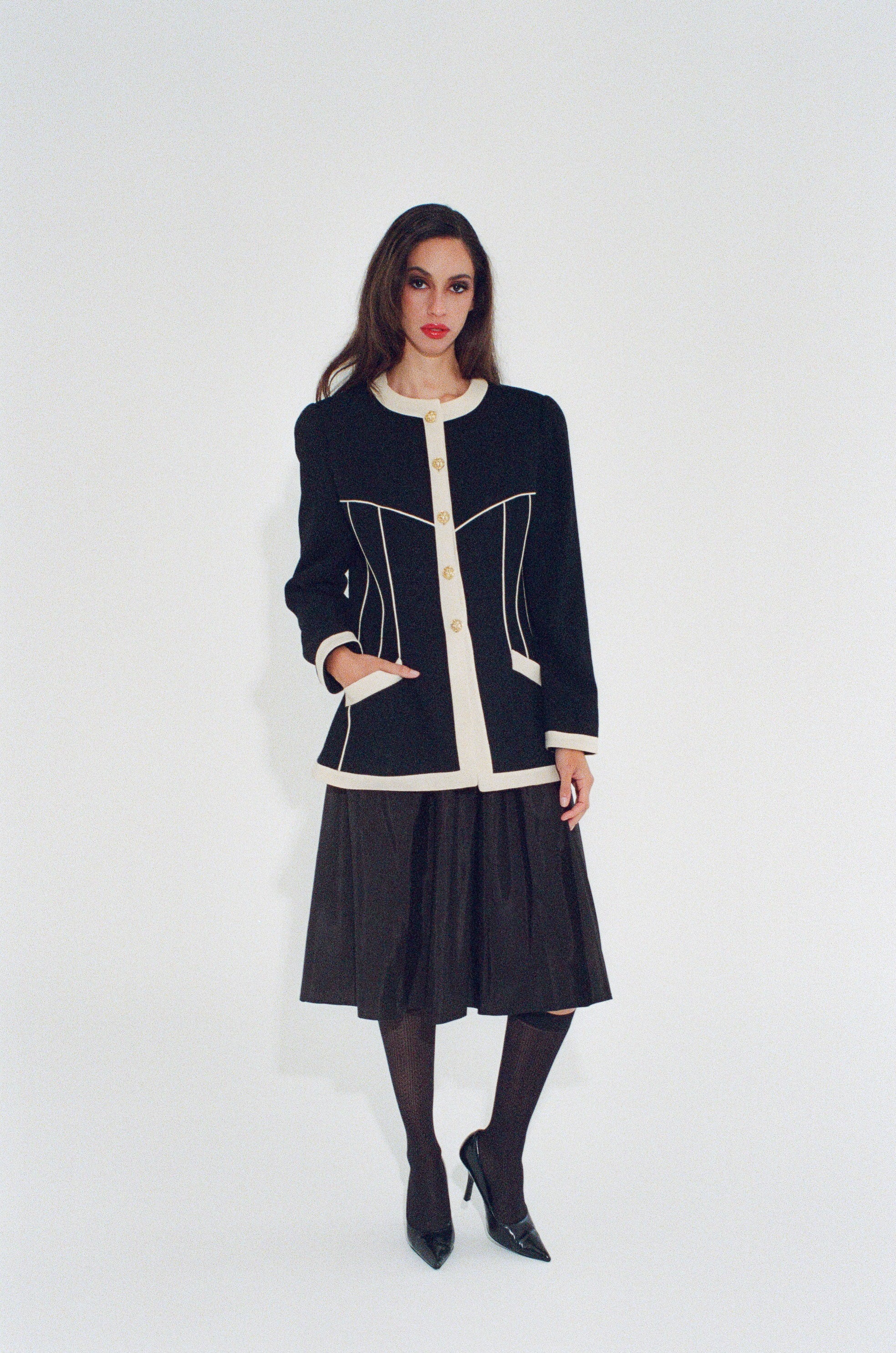 Woman wearing a black and white jacket with a white background