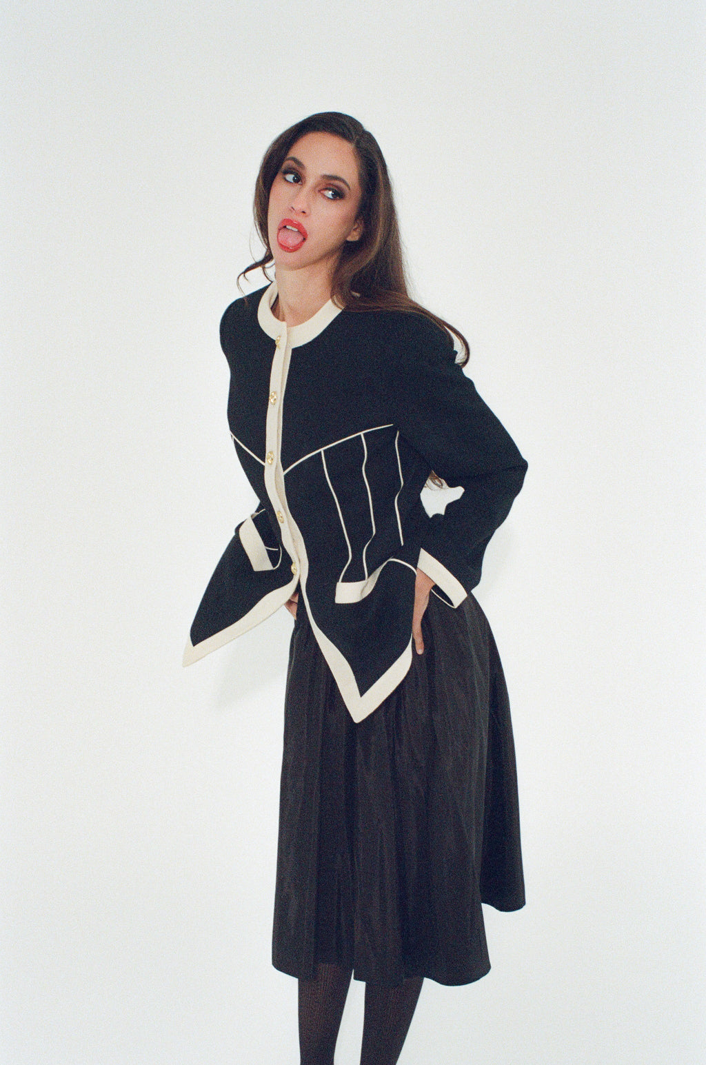 Woman wearing a black and white coat against a white background