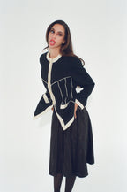 Woman wearing a black and white coat against a white background