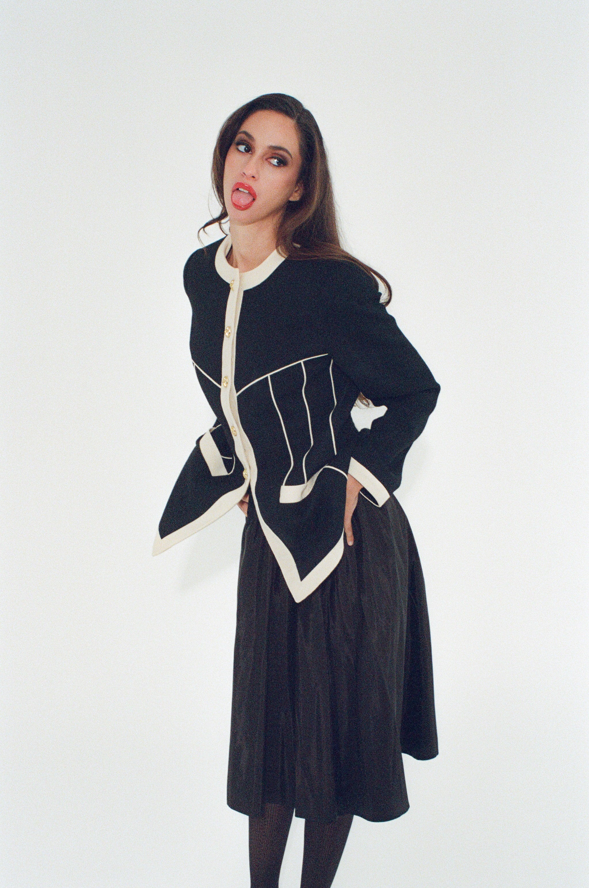 Woman wearing a black and white coat against a white background