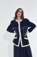 Woman wearing a black and white jacket on a white background