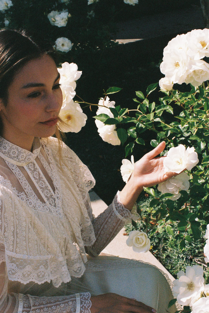 Woman in a garden with white flowers and lace clothing