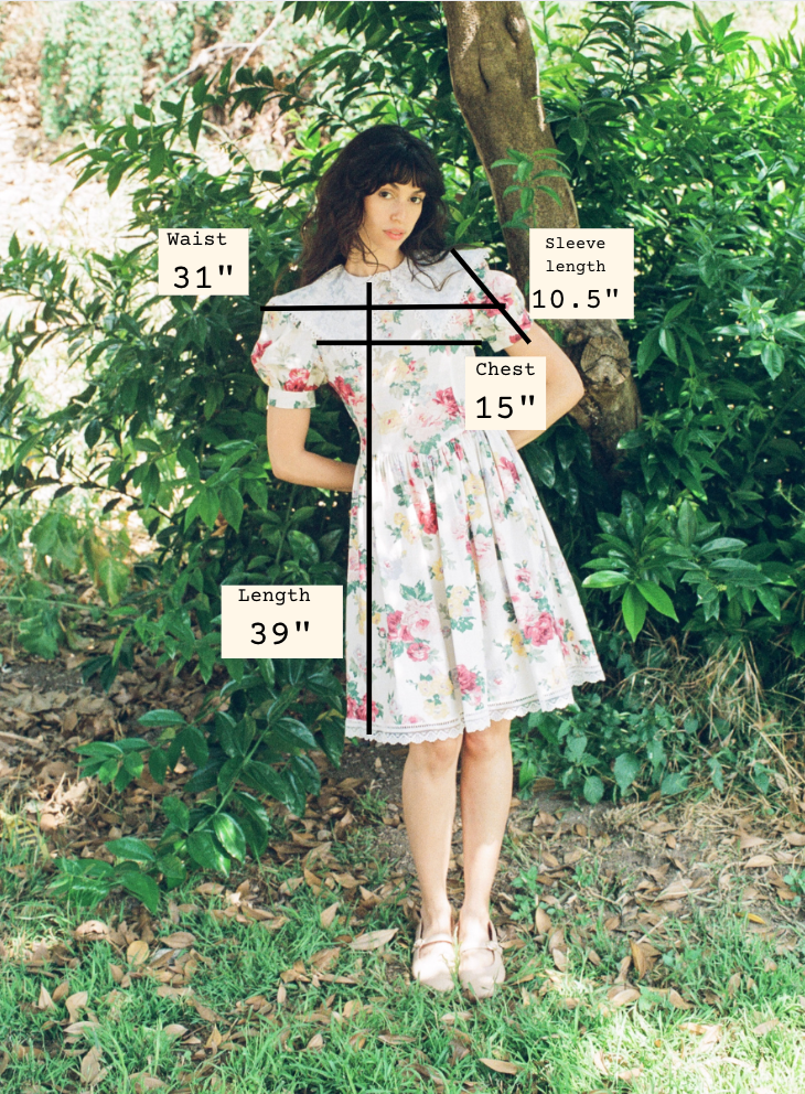 Woman wearing a floral dress with measurements overlaid on a natural background