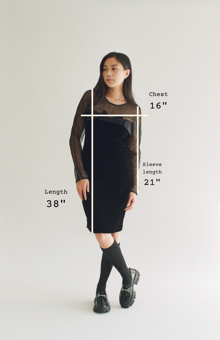 Person wearing a black dress with measurements indicated on a plain background
