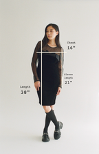 Person wearing a black dress with measurements indicated on a plain background
