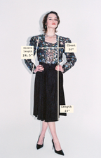 Model wearing a floral top dress with black skirt with measurements labeled on a white background
