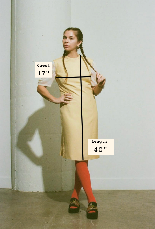 Woman wearing a beige dress with measurements labeled on a plain background