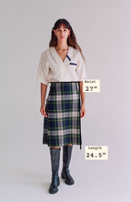Woman wearing a plaid skirt with measurements displayed on a plain background