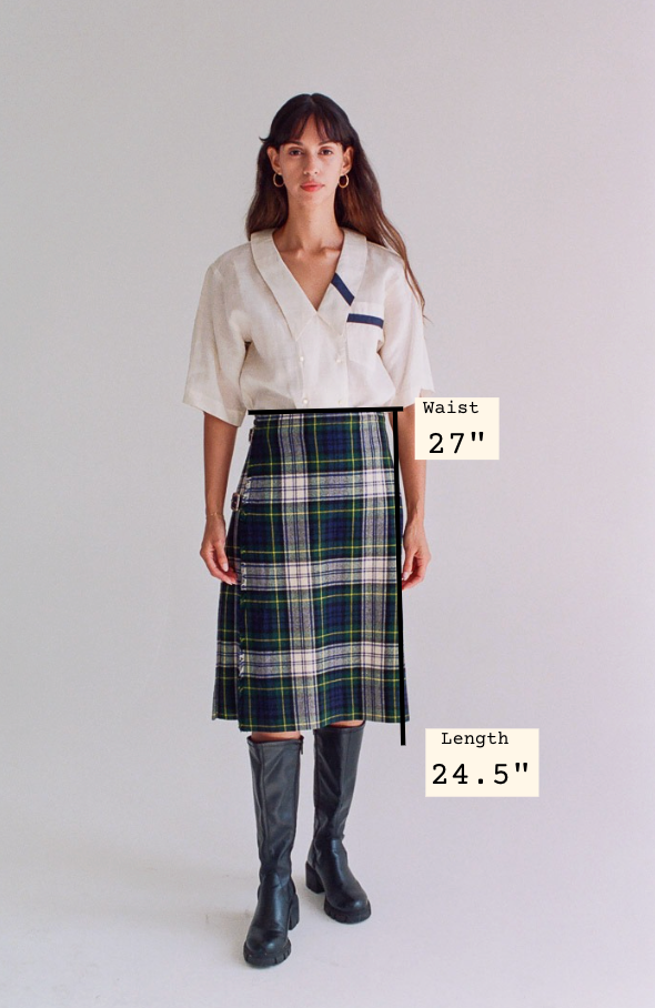 Woman wearing a plaid skirt with measurements displayed on a plain background