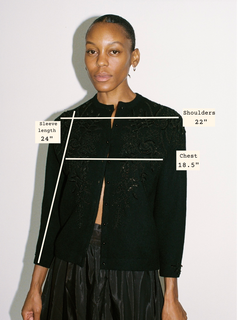 Woman wearing a black jacket with measurements labeled on a white background