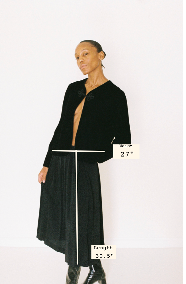 Model wearing a black dress with measurements indicated on a white background