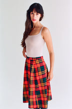 Woman wearing a white tank top and red plaid skirt on a white background