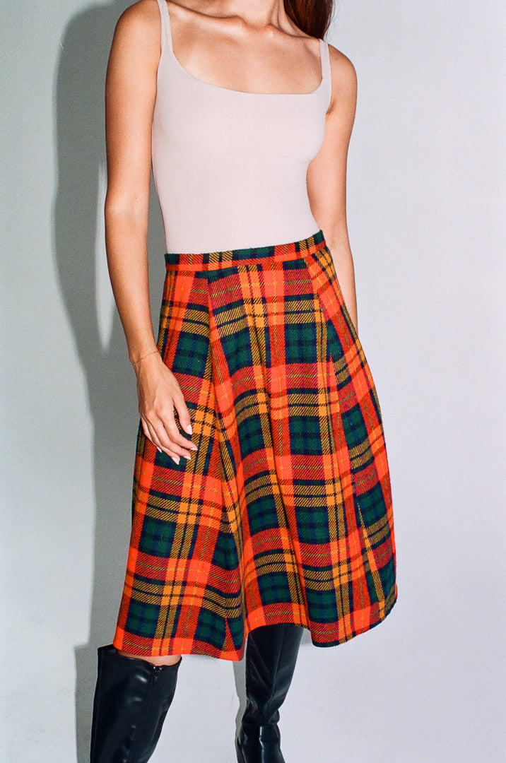 Person wearing a plaid skirt with a plain background