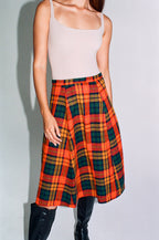 Person wearing a plaid skirt with a plain background