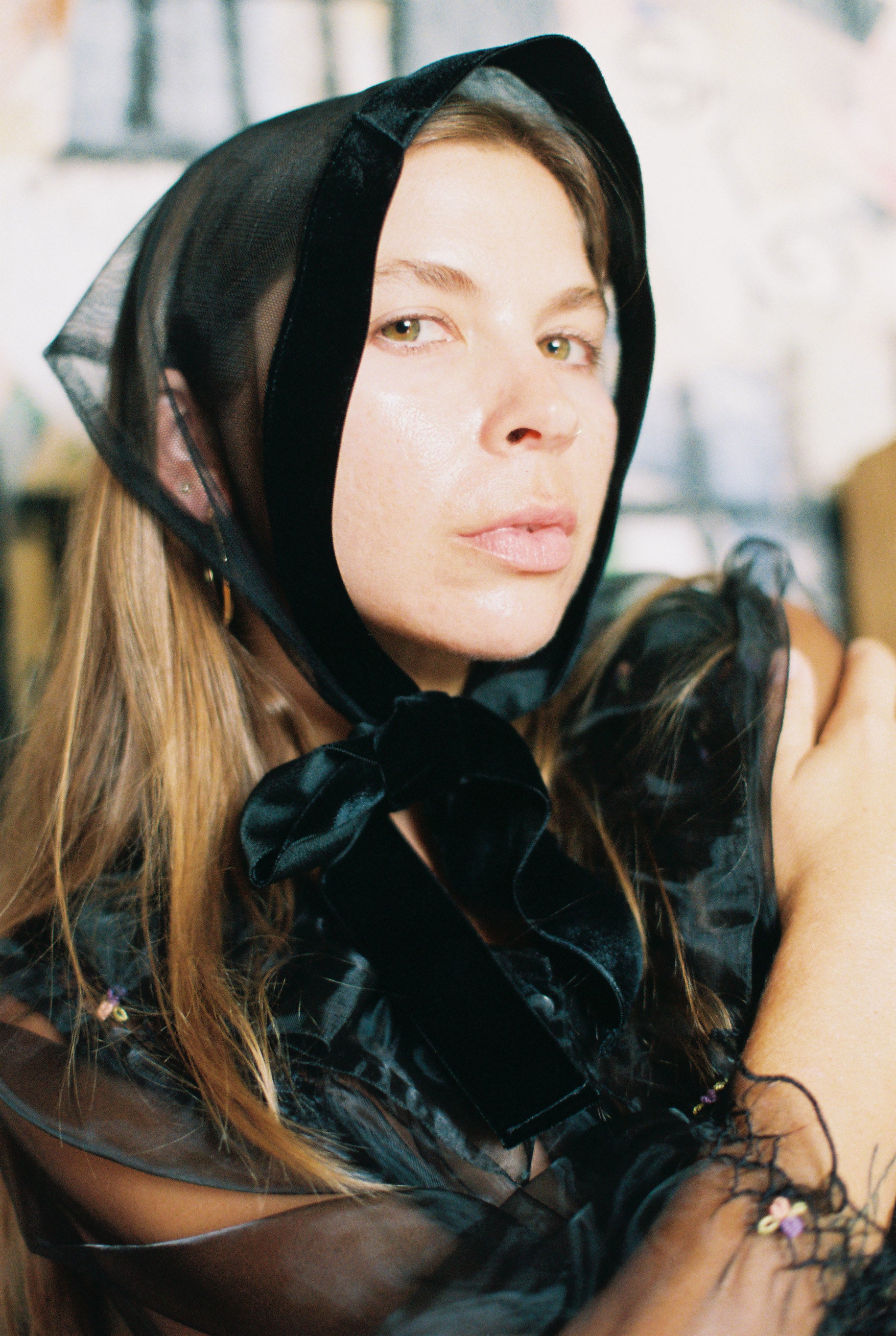 Woman wearing a black hooded garment with sheer overlay