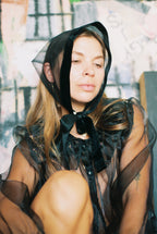 Person wearing a black sheer bonnet in an urban setting