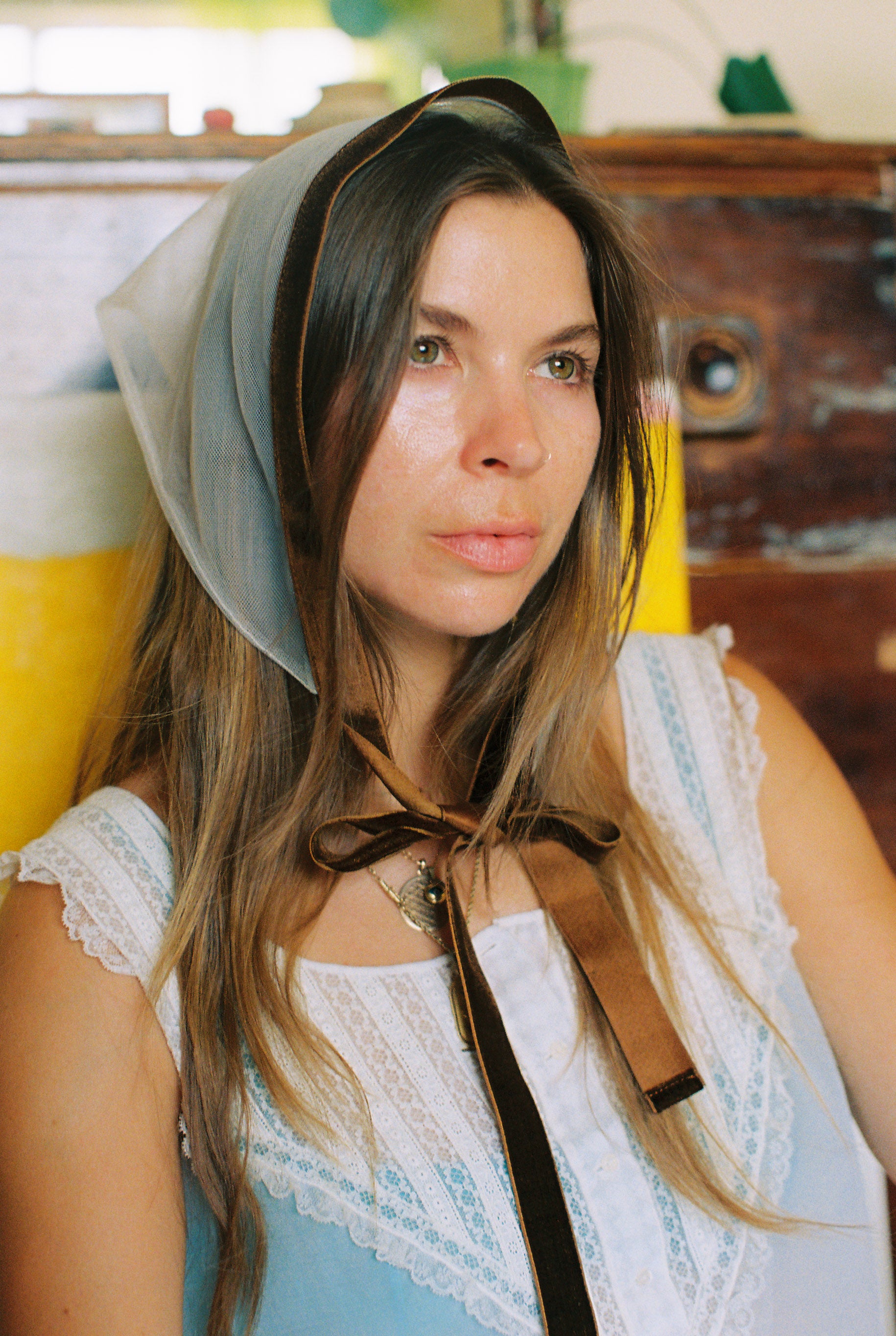 Woman wearing a headscarf with a brown ribbon in a casual setting