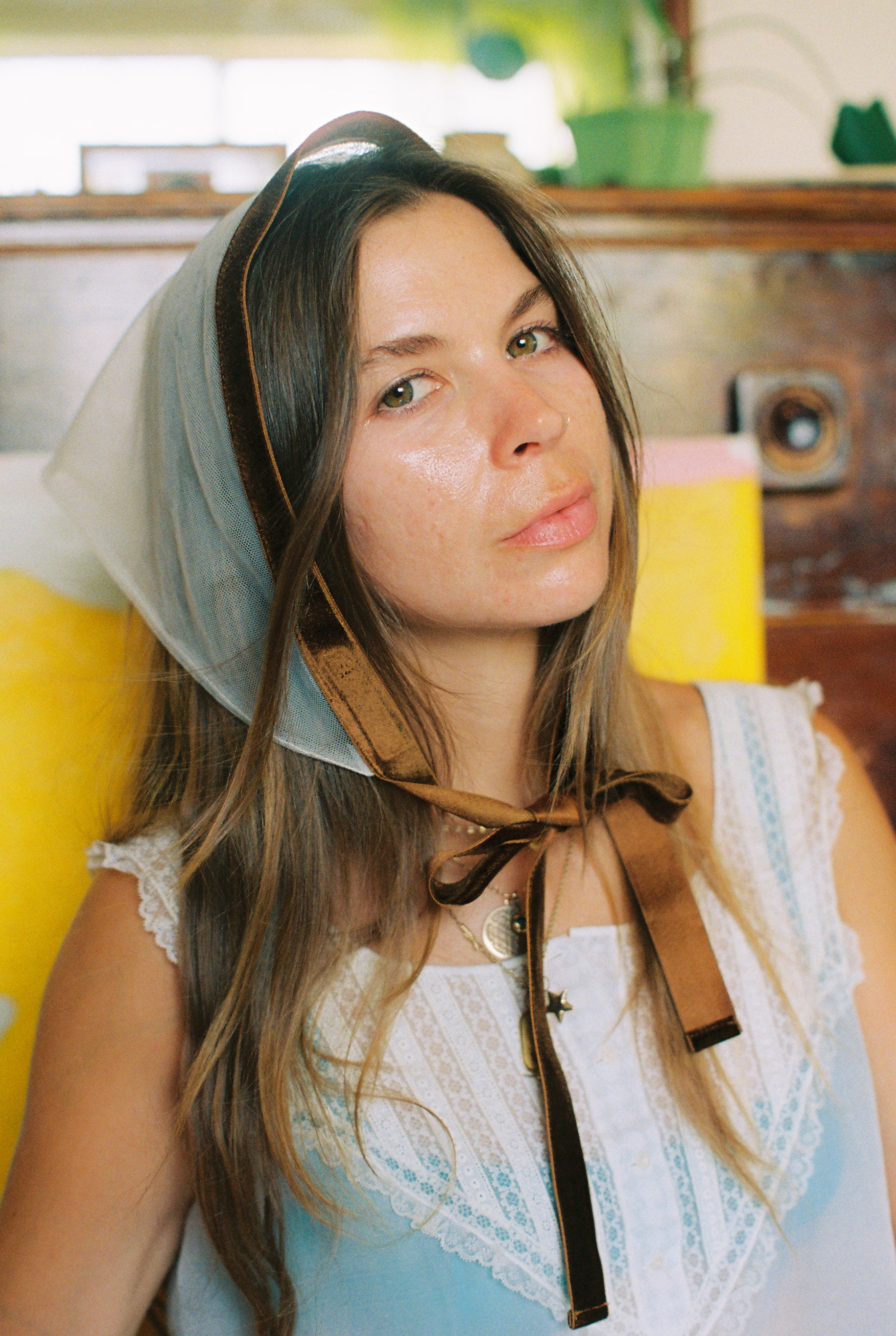 Woman wearing a headscarf with a vintage suitcase in the background