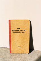 Notebook with 'The Western Union Telegraph Co.' text on a beige background
